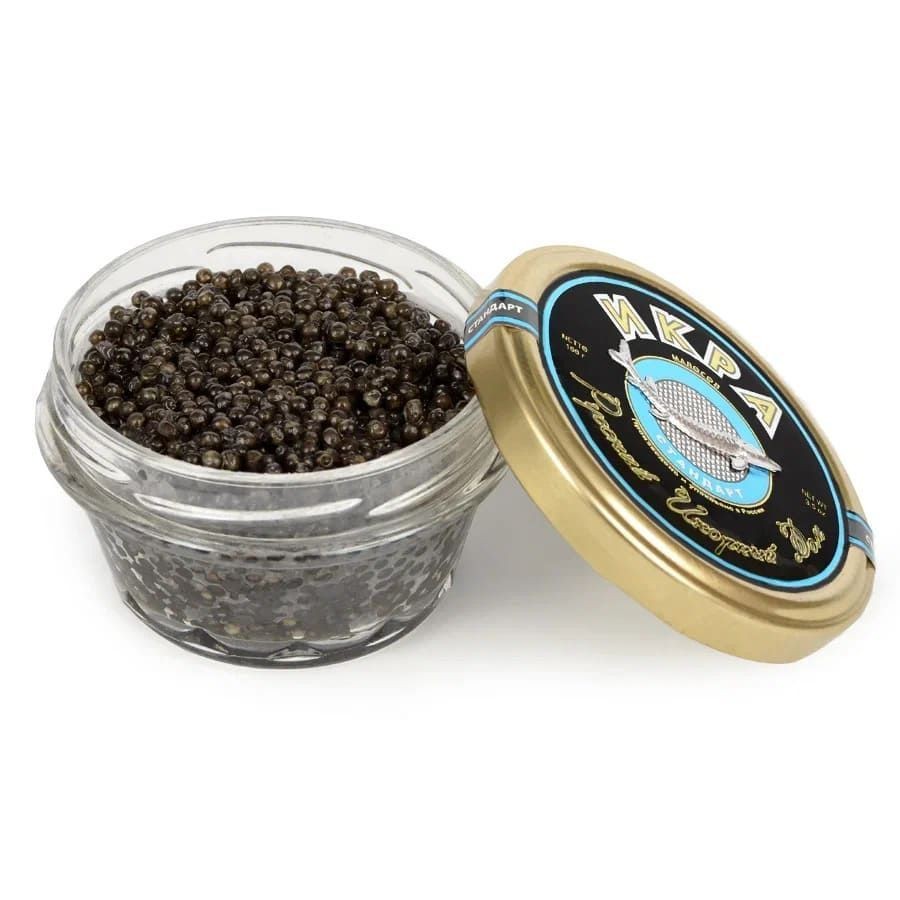 Glass jar filled with black caviar, partially open with the lid resting on the side.