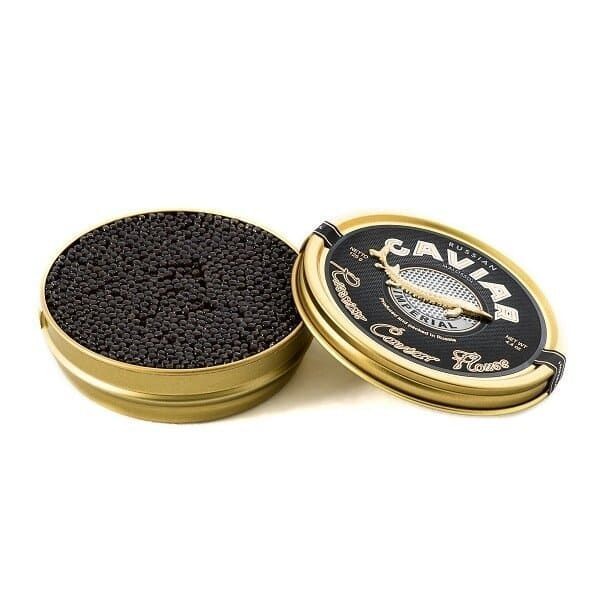 Open tin of black caviar with gold and black lid placed beside it on a white background.